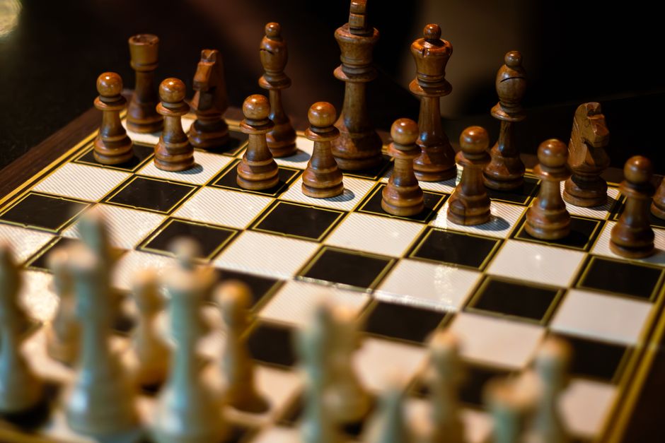 Intriguing chess game setup with wooden pieces on a black and white board.