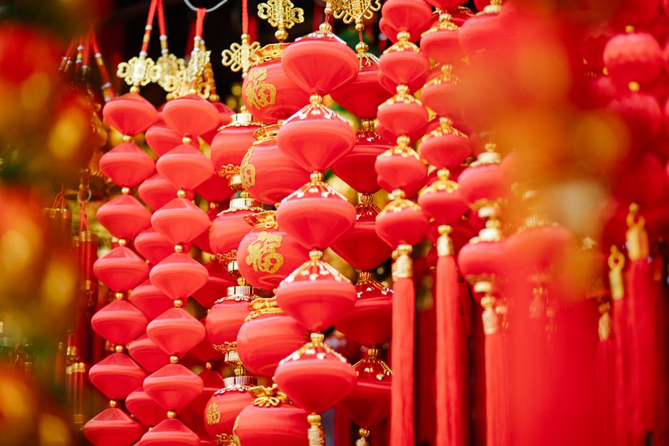 Traditional Chinese feng shui red decorations with golden details hanging in local street market during New Year holidays in daytime