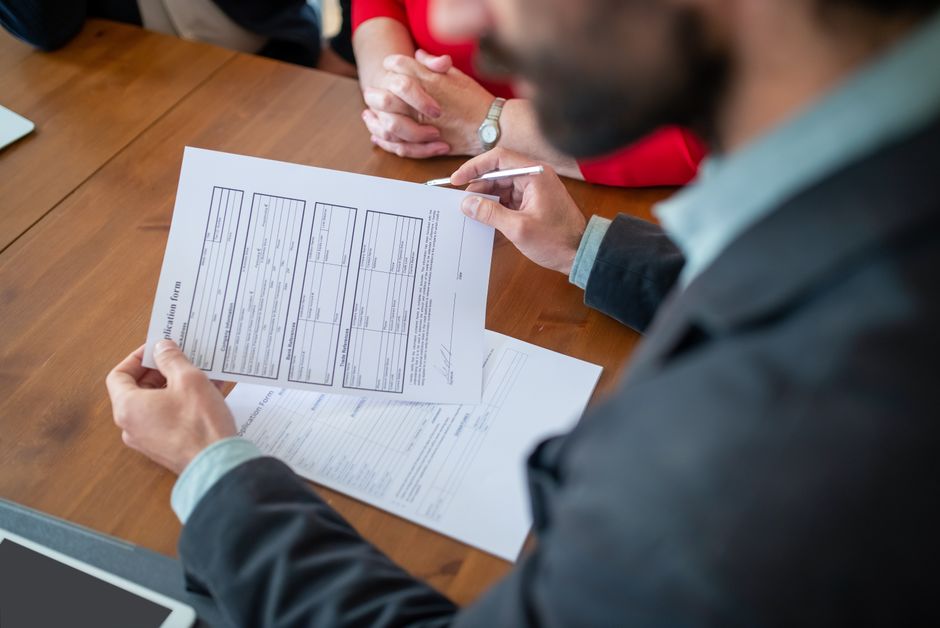 Close-up of businesspeople reviewing documents at a meeting.