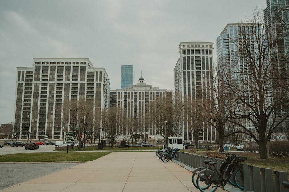 Bicycles lined up in front of apartment buildings in Chicago on a cloudy day.