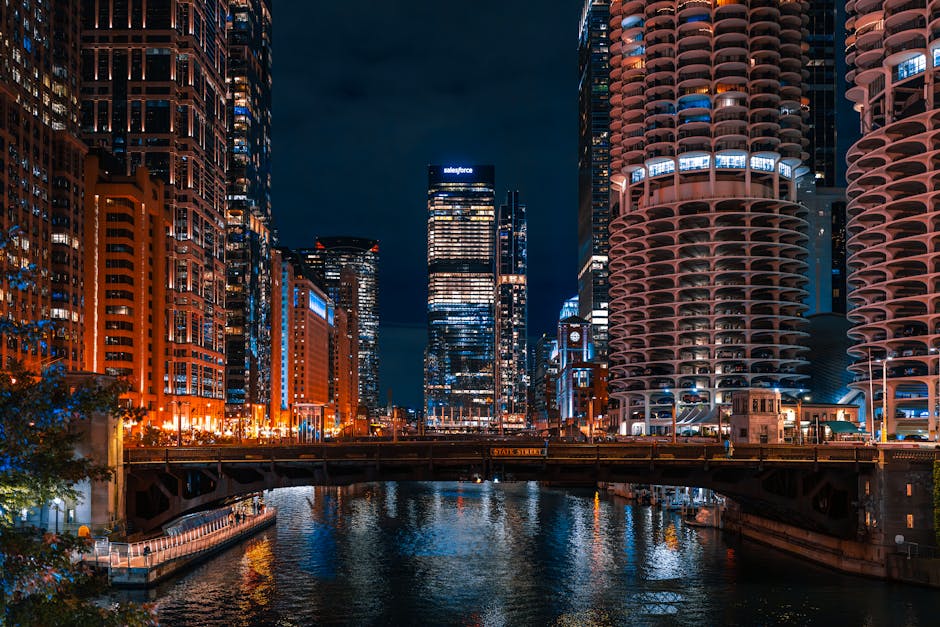 A captivating night view of the Chicago River flanked by towering skyscrapers and illuminated city lights.