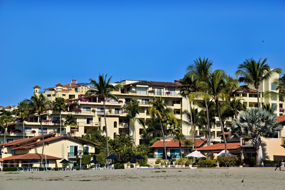 Tropical resort in Puerto Vallarta, Mexico, surrounded by palm trees and blue skies.