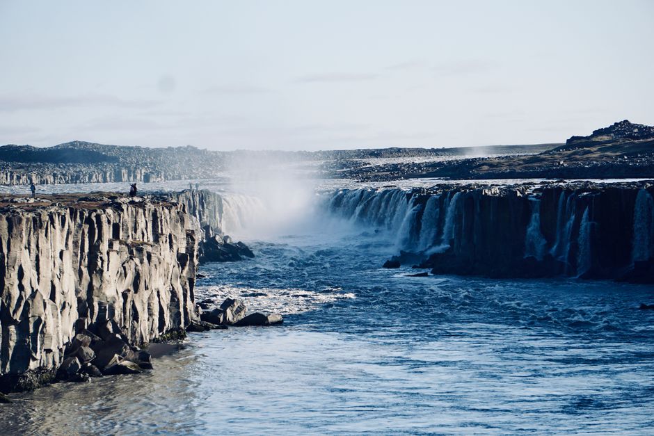 Breathtaking view of Selfoss waterfall cascading over Iceland's dramatic rocky cliffs under a clear sky.
