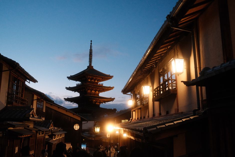 Serene view of Yasaka Pagoda in Kyoto's historic district at dusk, featuring illuminated traditional architecture.
