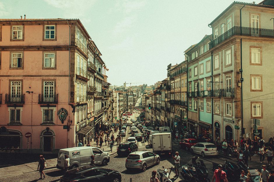 A bustling street scene in a historic European city with vibrant architecture and lively pedestrian activity.