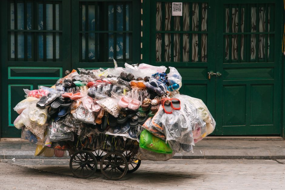 A cart loaded with recycled shoes and bags in Hanoi, Vietnam, showcasing urban recycling efforts.