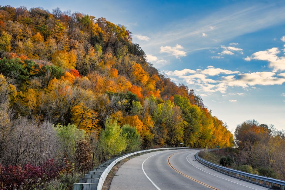 A serene road curves through vibrant autumn foliage in Stockholm, Wisconsin.