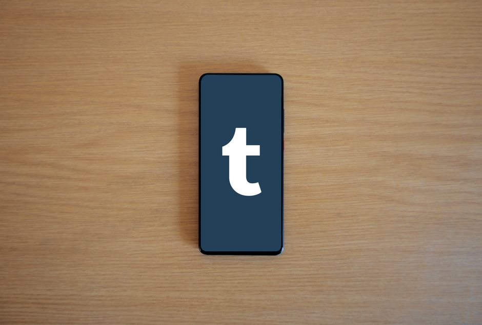 Smartphone displaying app logo on a wooden table, perfect for tech and lifestyle themes.