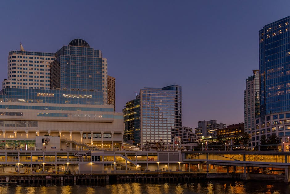 Modern Vancouver skyline at dusk with urban waterfront view, showcasing iconic architecture and cityscape reflections.