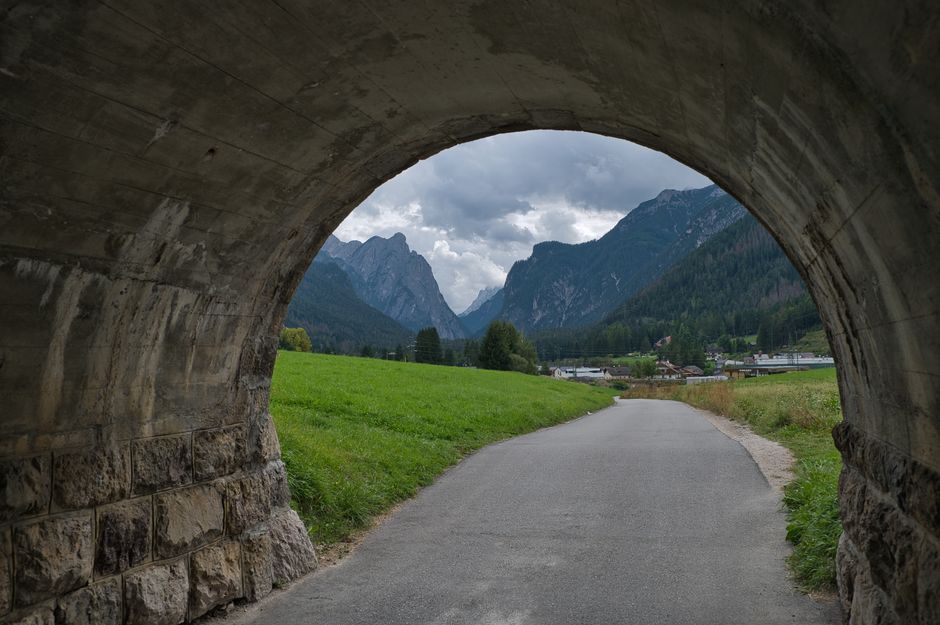 Picturesque landscape view through a tunnel opening in Toblach, Trentino-Südtirol, Italy.