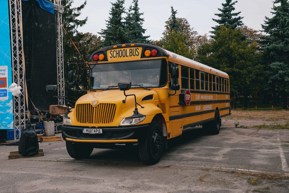 A classic yellow school bus parked at an event in Kyiv, showcasing a unique cultural twist on a familiar icon.