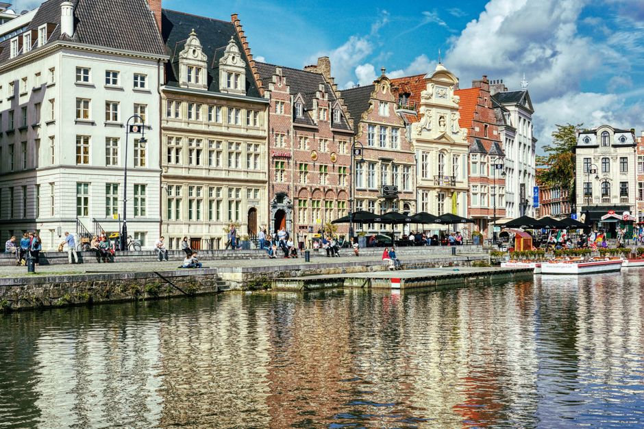Charming historic buildings along a canal in Ghent, Belgium, reflecting vibrant city life.