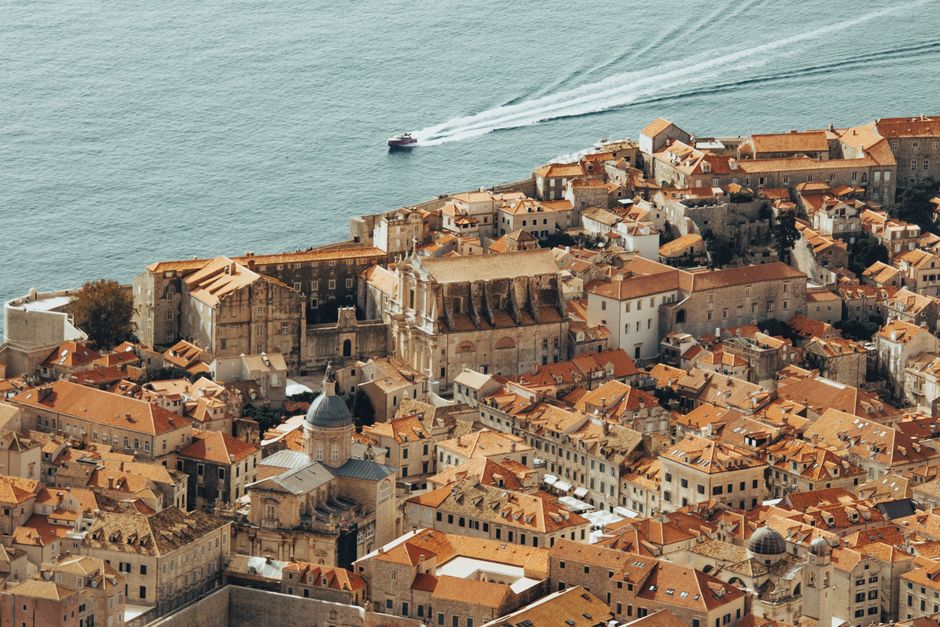 Aerial shot of Dubrovnik's Old Town featuring ancient architecture and the Adriatic Sea.