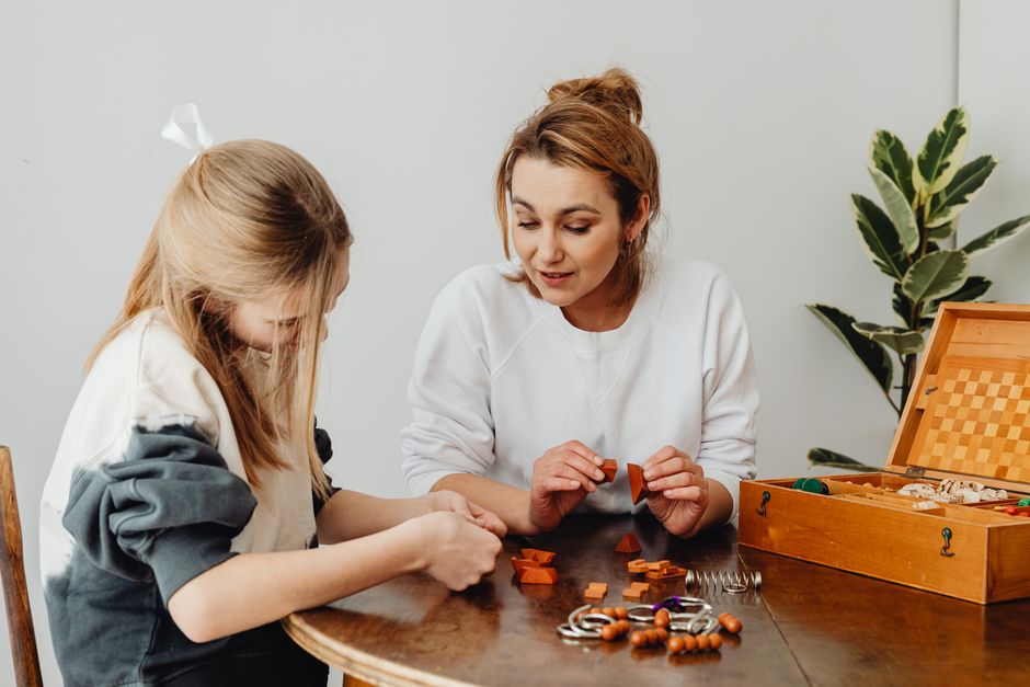 A mother and daughter enjoying a puzzle game indoors, fostering learning and bonding.